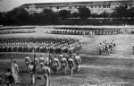 Topside' on Corregidor. Peacetime parade ground on this three mile long island. The Army barracks in the background were known as Mile-long barracks." 